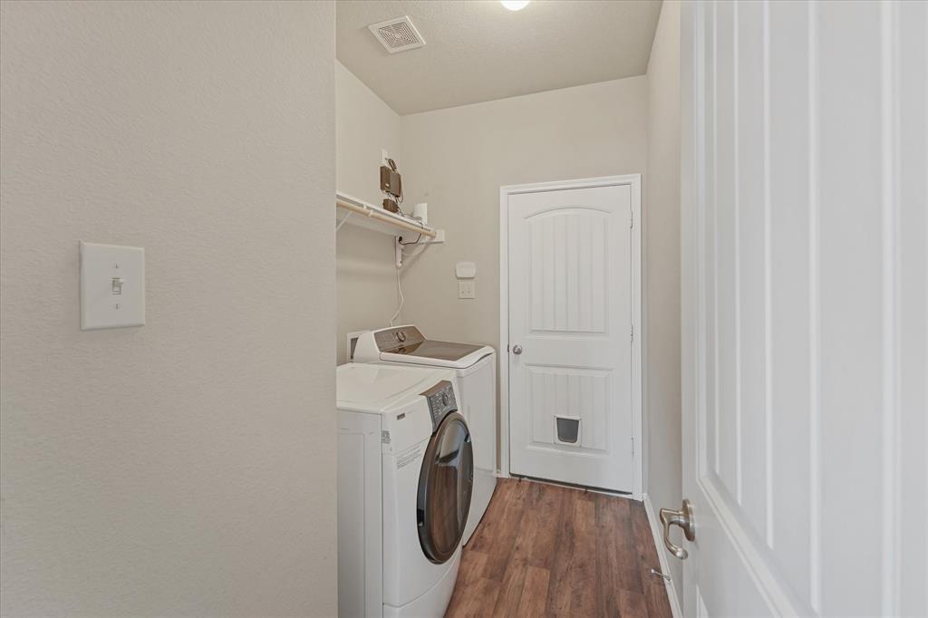 409 Harding Lane Lavon, TX 75166 - Photo 8 of 34 Dedicated laundry area featuring wood-finish flooring, a white paneled door, and a built-in wall shelf