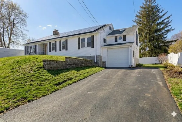 a front view of a house with a garden