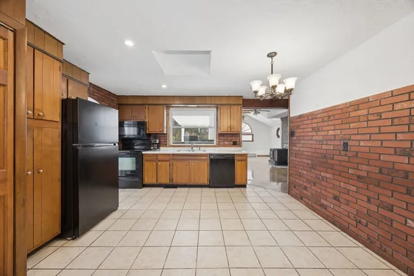 a large kitchen with granite countertop a refrigerator and a stove top oven