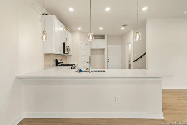 a view of kitchen with stainless steel appliances refrigerator sink and cabinets