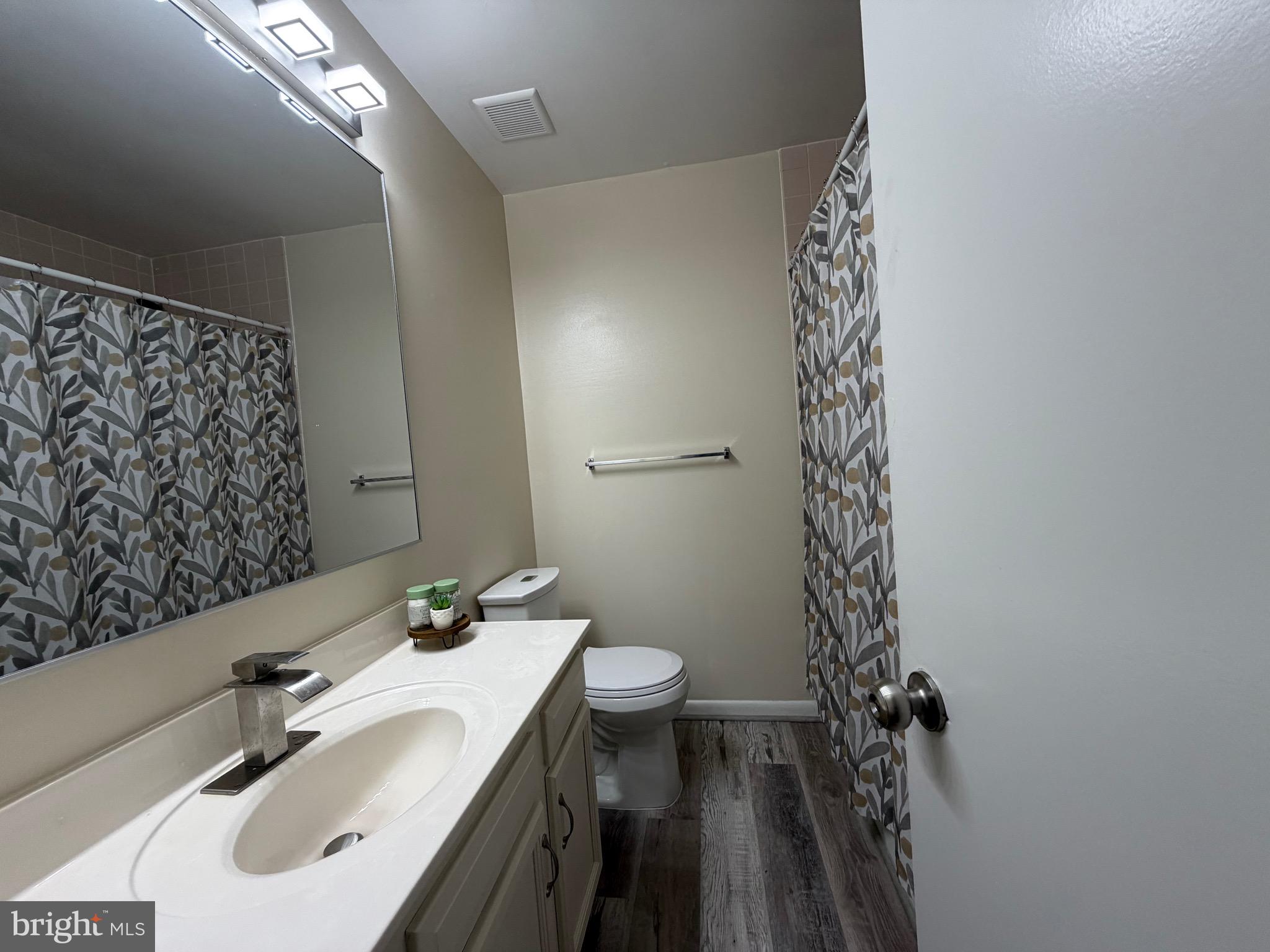 18 Jameson Lane Baltimore, MD 21208 - Photo 20 of 39 a bathroom with a sink a toilet and shower curtain