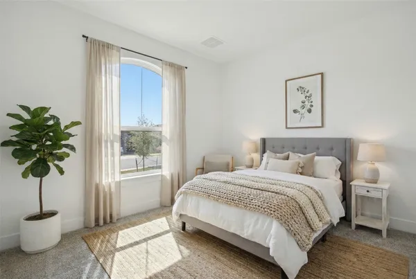 a bedroom with a bed and a potted plant