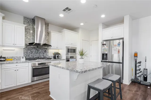 a kitchen with stainless steel appliances granite countertop a stove refrigerator sink and cabinets