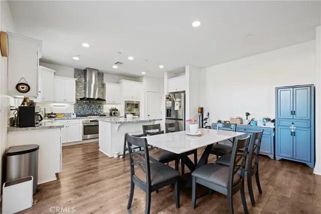a kitchen with a dining table chairs stainless steel appliances and cabinets