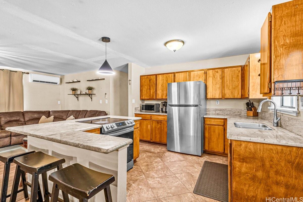 4806 Iiwi Road Kapaa, HI 96746 - Photo 14 of 25 a kitchen with granite countertop a sink stove and refrigerator