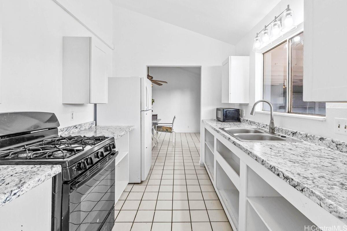 4806 Iiwi Road Kapaa, HI 96746 - Photo 3 of 25 a kitchen with a stove and a sink