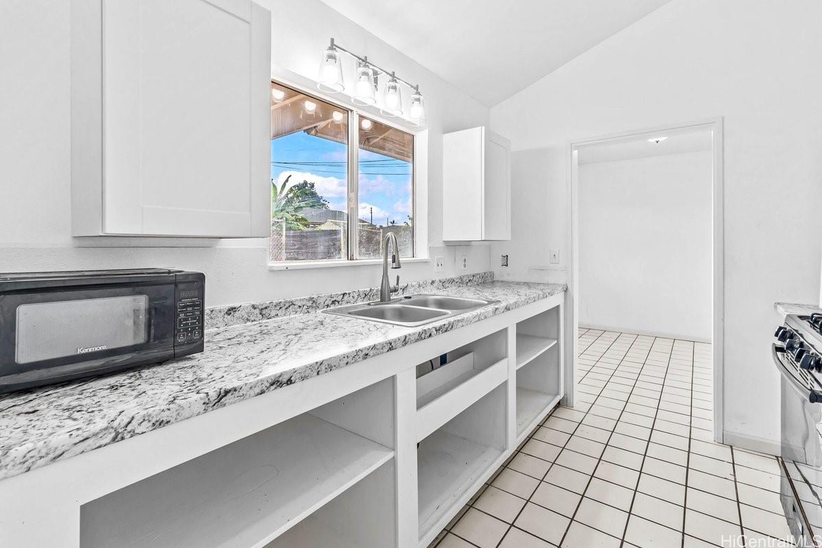 4806 Iiwi Road Kapaa, HI 96746 - Photo 4 of 25 a kitchen with stainless steel appliances granite countertop a sink stove and cabinets