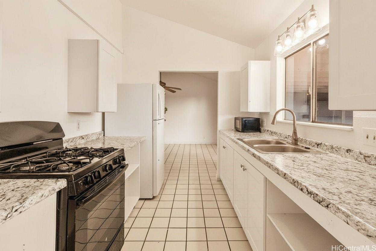 4806 Iiwi Road Kapaa, HI 96746 - Photo 5 of 25 a kitchen with a stove and a sink
