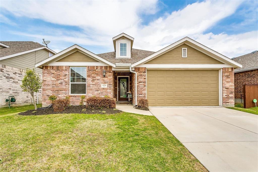 View of front of house with brick siding, a front yard, concrete driveway, a shingled roof, and an attached garage