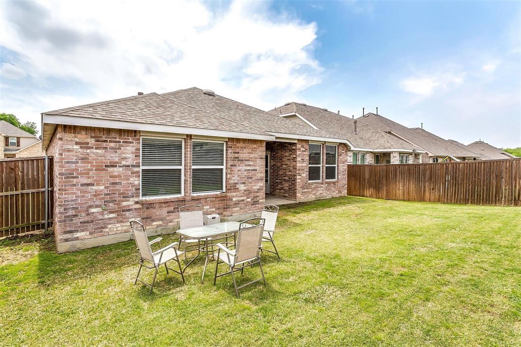 1629 Ridge Creek Lane Aubrey, TX 76227 - Photo 23 of 25 Rear view of property featuring brick siding, roof with shingles, a fenced backyard, and a patio area