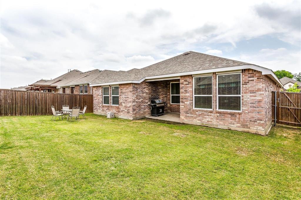 1629 Ridge Creek Lane Aubrey, TX 76227 - Photo 24 of 25 Back of house with brick siding, a patio area, a fenced backyard, and a shingled roof