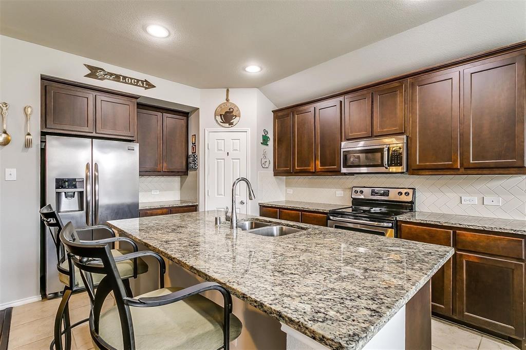 1629 Ridge Creek Lane Aubrey, TX 76227 - Photo 9 of 25 Kitchen featuring backsplash, light tile patterned floors, stainless steel appliances, light stone countertops, and recessed lighting