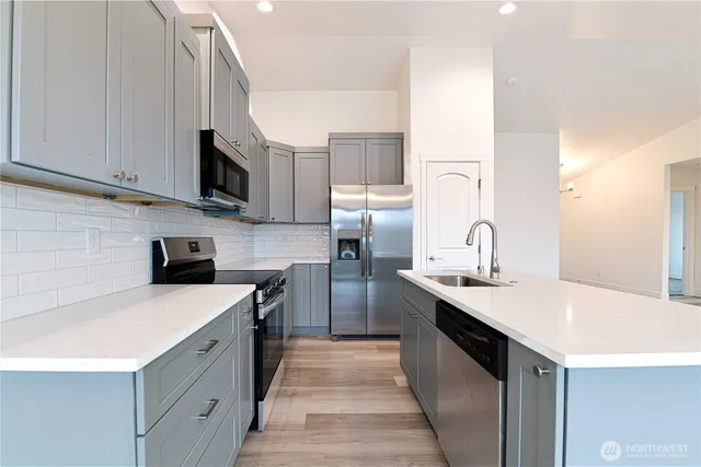 a kitchen with kitchen island a sink stainless steel appliances and cabinets
