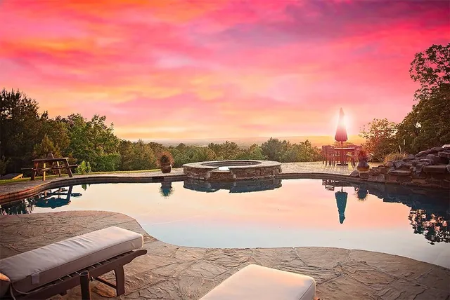 a view of swimming pool with lawn chairs and a yard