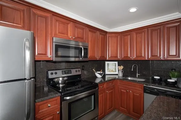 a kitchen with stainless steel appliances granite countertop a refrigerator stove top oven and sink