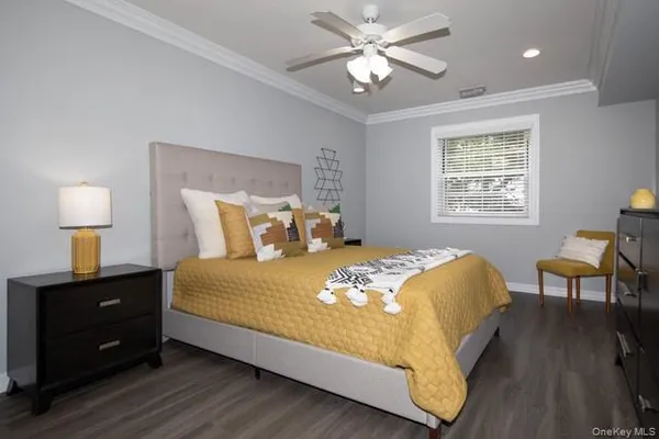 a large bed sitting in a bedroom next to a window and a chandelier