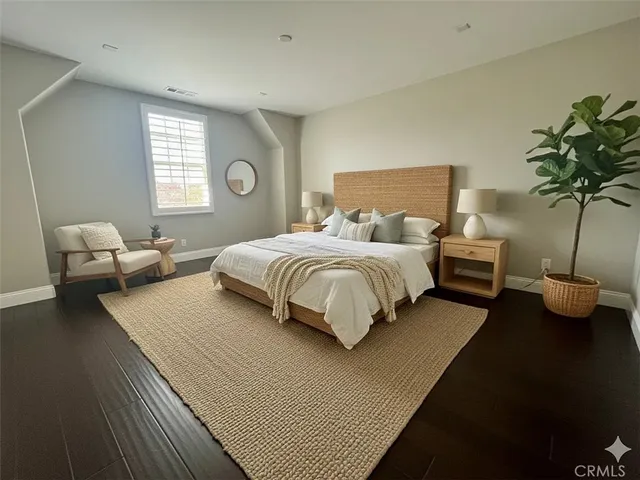 a bedroom with bed and a potted plant