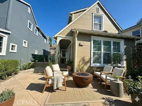 a view of a patio with couches table and chairs and potted plants