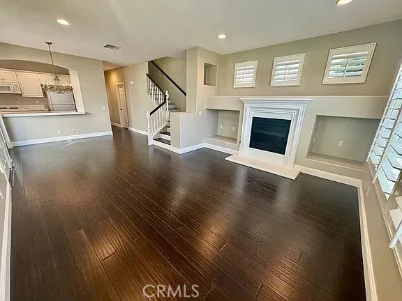 a view of a livingroom with wooden floor a fireplace and window
