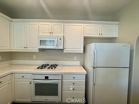 6 Evergreen Road Ladera Ranch, CA 92694 - Photo 8 of 27 a kitchen with white cabinets and white appliances
