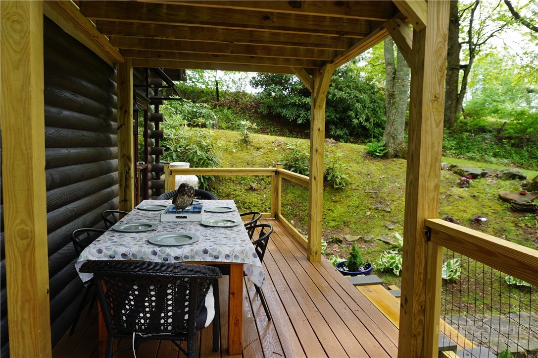 557 White Pine Road Newland, NC 28657 - Photo 22 of 41 a view of a patio with table and chairs with wooden floor fence and roof