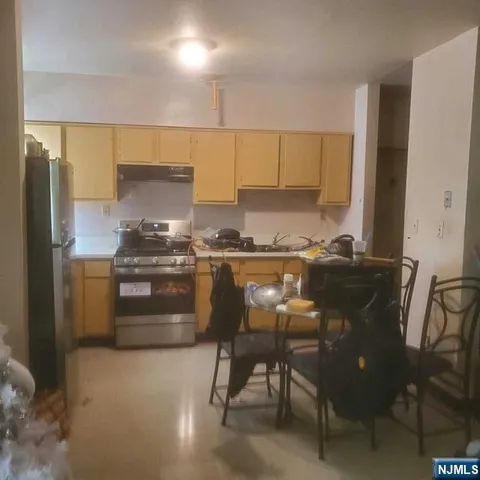 a kitchen with a table chairs refrigerator and microwave
