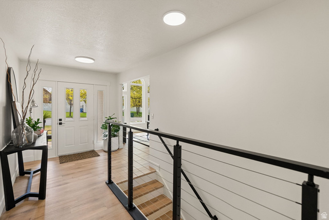 368 Spring Creek Road Providence, UT 84332 - Photo 20 of 45 Foyer entrance featuring light wood-type flooring and a textured ceiling