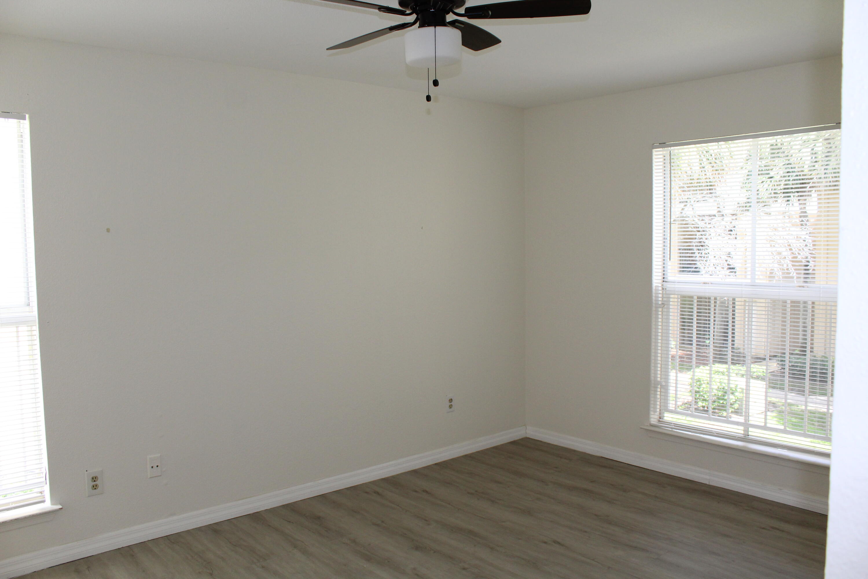 899 Riverside Drive, Unit 620 Coral Springs, FL 33071 - Photo 36 of 46 an empty room with wooden floor fan and windows