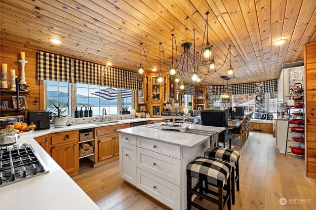 a kitchen that has a lot of cabinets in it and wooden floor
