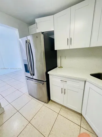 a kitchen with a sink cabinets and a refrigerator