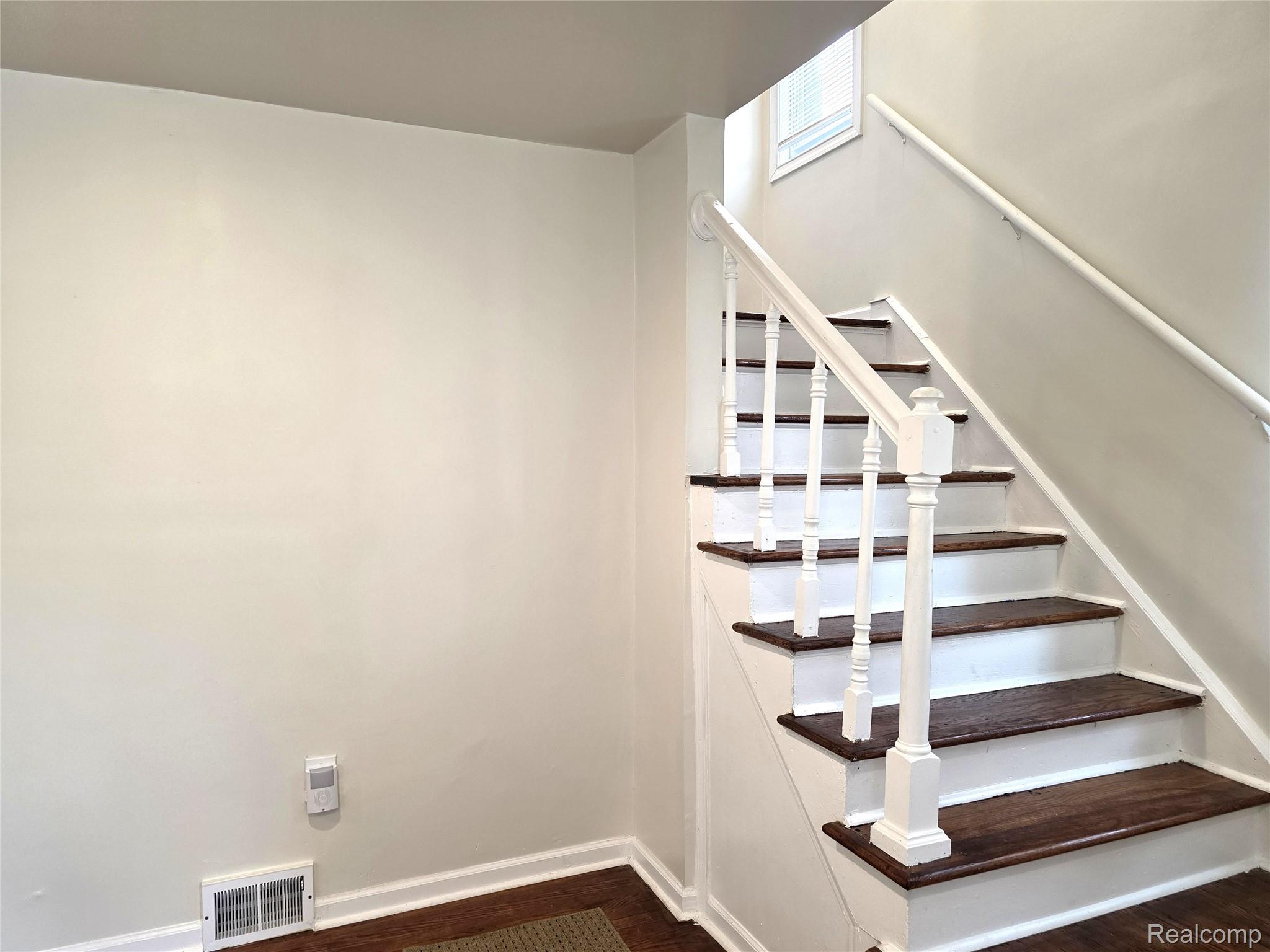 16814 Strathmoor Street Detroit, MI 48235 - Photo 11 of 31 Staircase with dark wood-finish treads, white risers, and white balusters