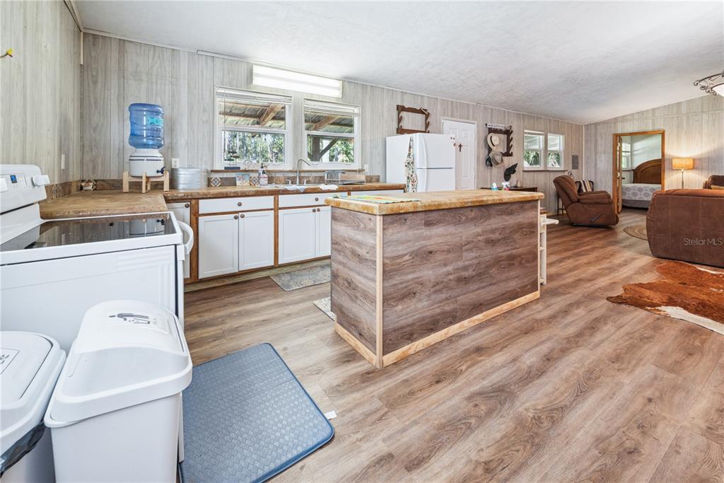 6550 Southwest 100 Court Cedar Key, FL 32625 - Photo 18 of 41 a kitchen with a stove a sink and a refrigerator