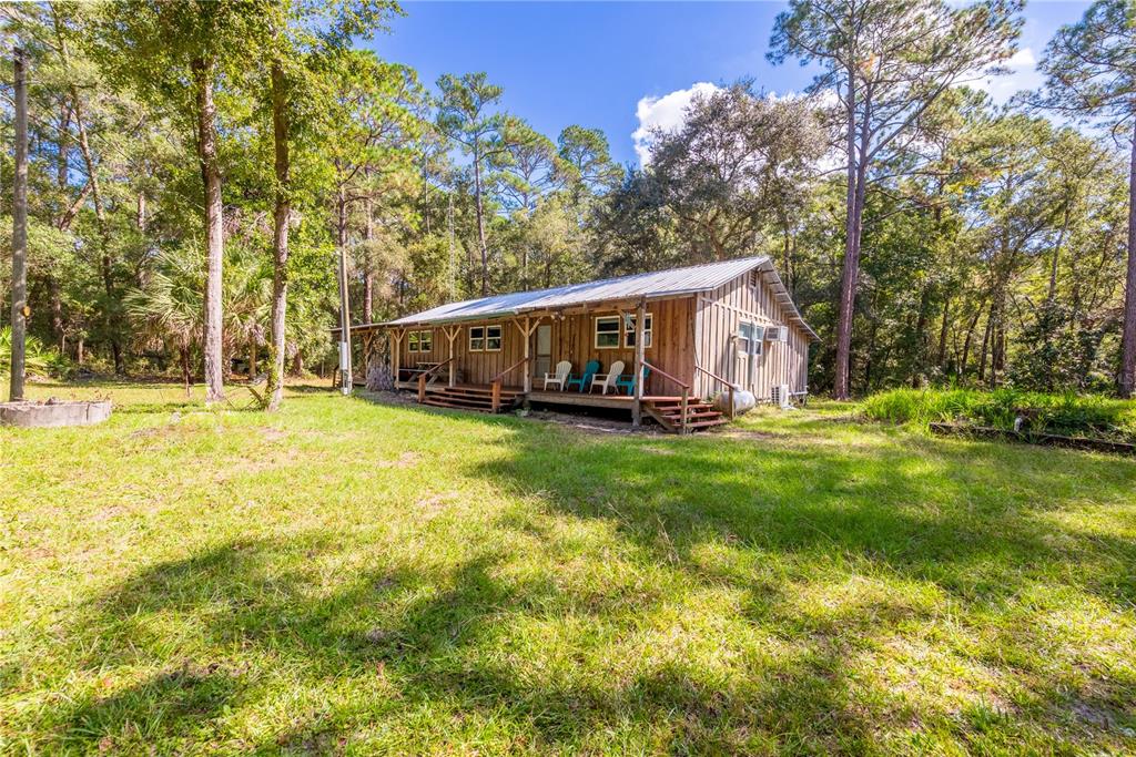 6550 Southwest 100 Court Cedar Key, FL 32625 - Photo 2 of 41 a view of a house with a big yard and large trees