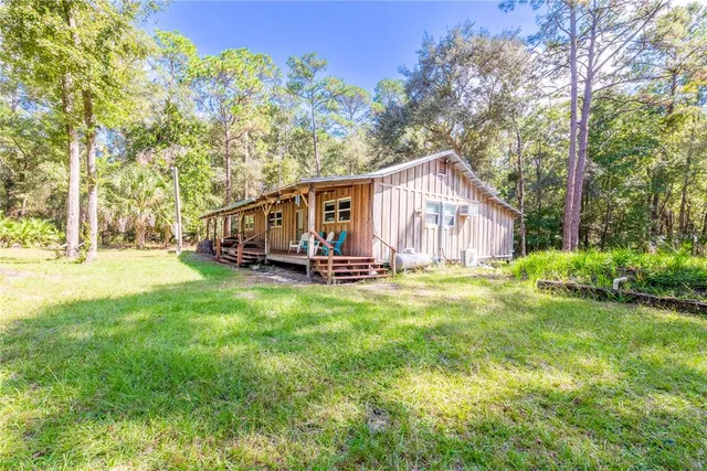 a view of a house with backyard and sitting area