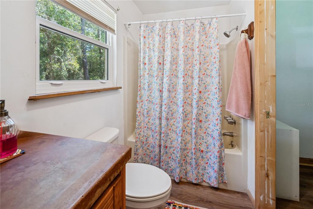 6550 Southwest 100 Court Cedar Key, FL 32625 - Photo 33 of 41 a white toilet sitting next to a shower curtain