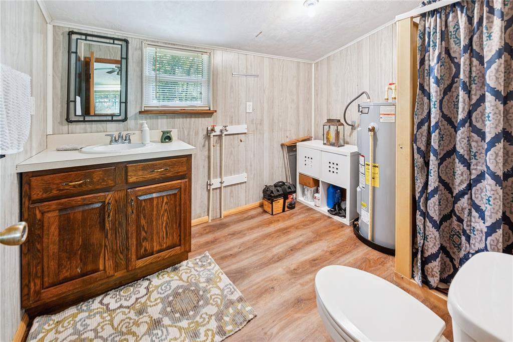 6550 Southwest 100 Court Cedar Key, FL 32625 - Photo 35 of 41 a spacious bathroom with a sink a mirror a toilet and a window