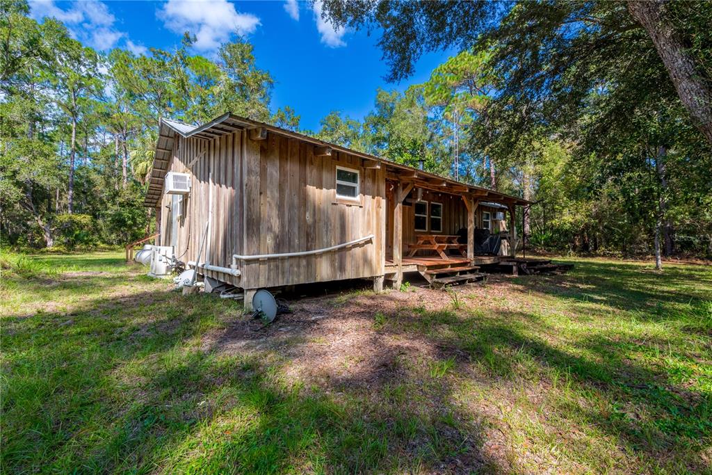 6550 Southwest 100 Court Cedar Key, FL 32625 - Photo 7 of 41 a backyard of a house with barbeque oven table and chairs
