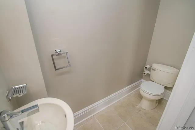 a white toilet sitting next to a white sink and vanity