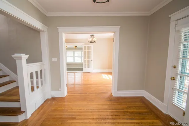 a view of an empty room with glass door and wooden floor