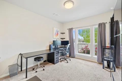 a view of a workspace with furniture and a window