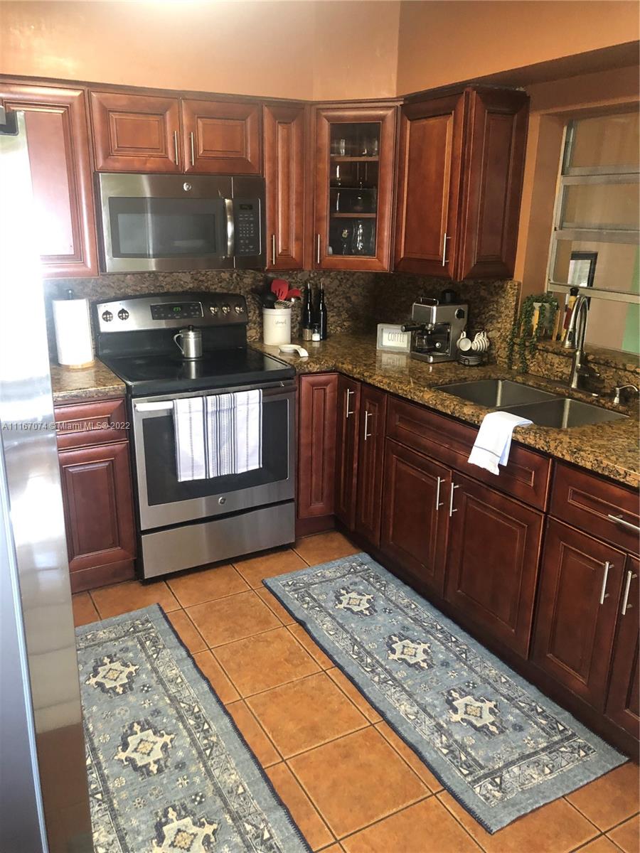172 West 17th Street Hialeah, FL 33010 - Photo 11 of 27 a kitchen with stainless steel appliances granite countertop a stove a sink and a microwave