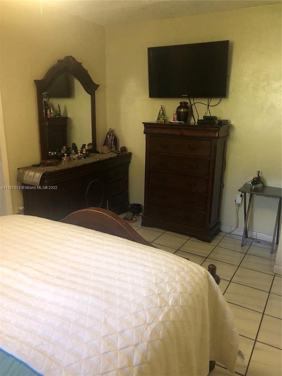 172 West 17th Street Hialeah, FL 33010 - Photo 13 of 27 a bedroom with a bed and flat screen tv