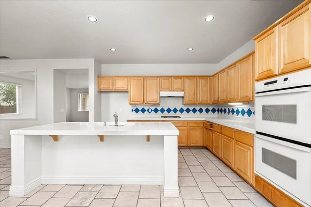 a kitchen with stainless steel appliances granite countertop a stove a sink and a microwave