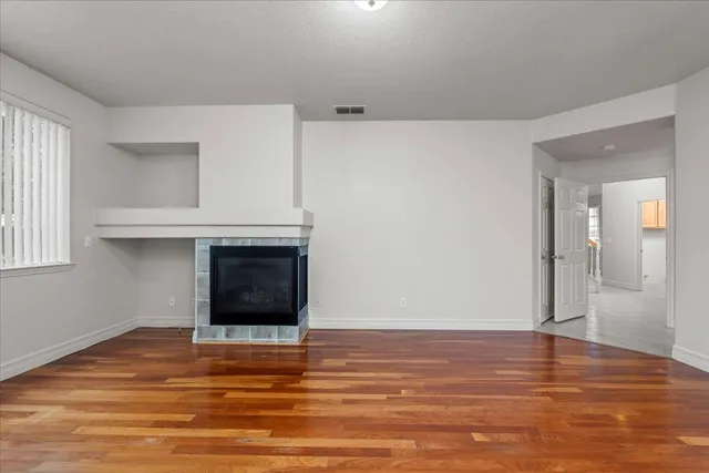 a view of a room with wooden floor and a fireplace