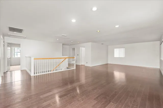 a view of a hallway with wooden floor and windows