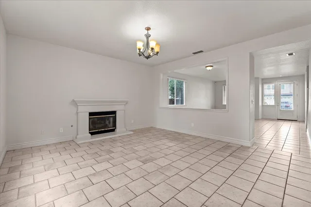 an empty room with windows and fireplace