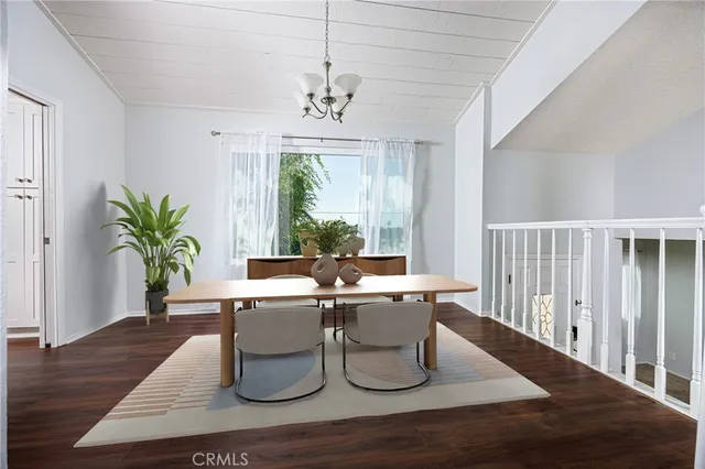 a dining room with wooden floor a chandelier a glass table and chairs