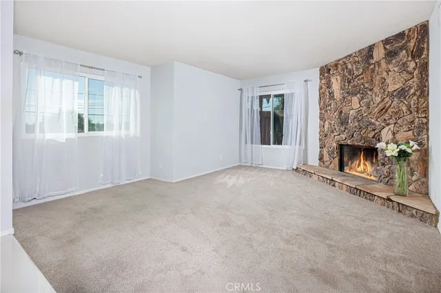 a view of empty room with fireplace and window