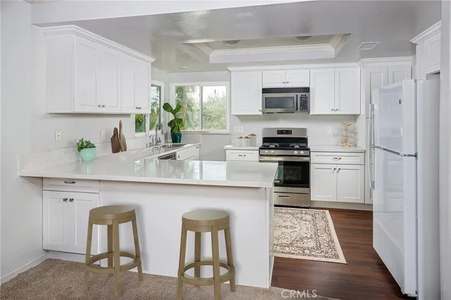 a kitchen with stainless steel appliances granite countertop a stove a sink and a refrigerator