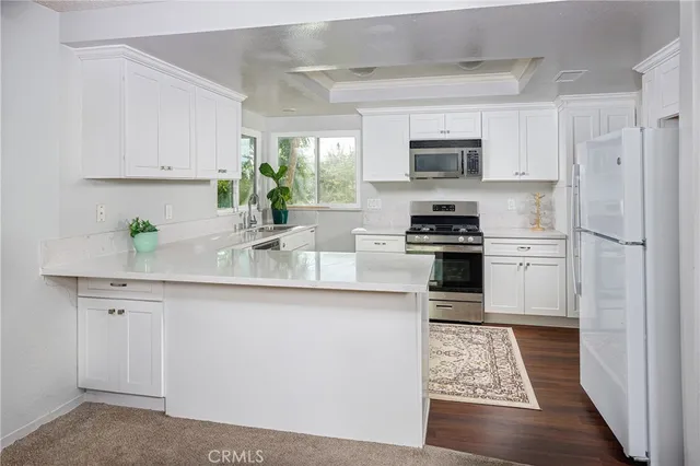 a kitchen with stainless steel appliances granite countertop a refrigerator sink and stove